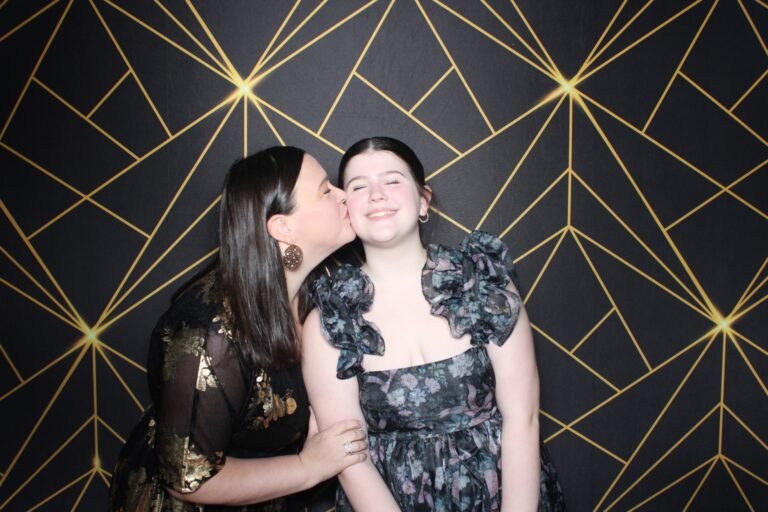 Guests sharing a playful kiss at a fundraiser photo booth