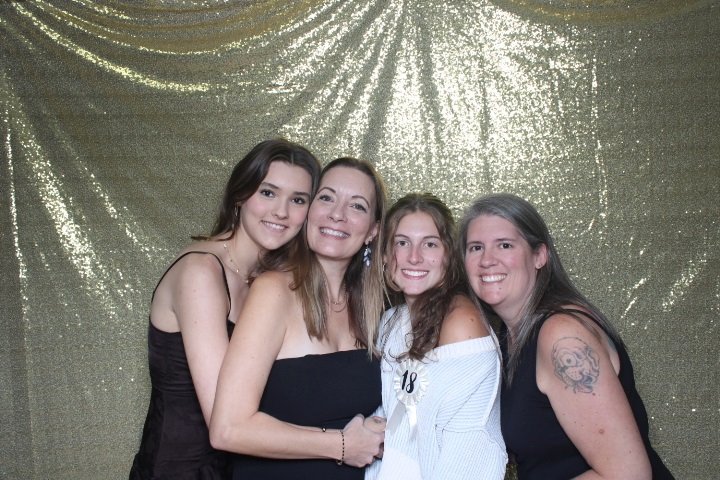 Friends posing together at a birthday party photo booth